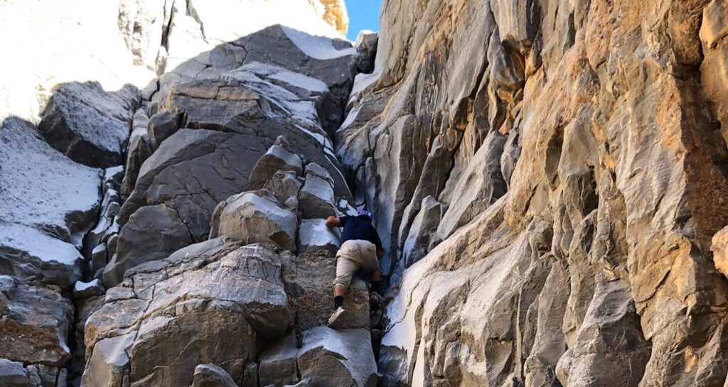 Hikers scrambling through Leopard Canyon in Ras Al Khaimah, UAE