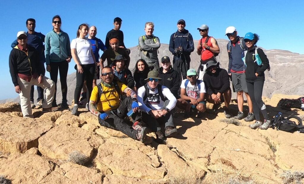 Alpine Trekkers hiking group on a mountain summit in Wadi Shah, Ras Al Khaimah, UAE